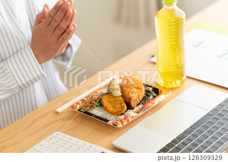 会社のデスクでのり弁当を食べるミドル女性 126309329