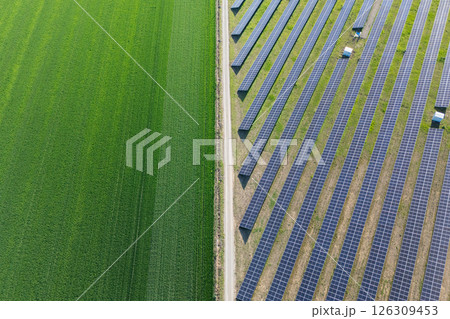 Aerial view of solar power station and green agricultural field. Sustainable development 126309453