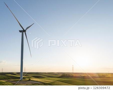 Wind turbine on an agricultural filed at sunset 126309472