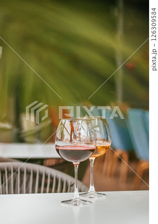 Two glasses of wine on a white table in a cozy setting Two glasses of wine on a white table in a cozy setting 126309584