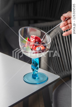 Elegant Italian dessert panna cotta with fresh berries and cream in a stylish glass Elegant Italian dessert panna cotta with fresh berries and cream in a stylish glass 126309595