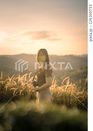 solo woman travel take photo and sightseeing sunrise on mountain at thailand 126309733