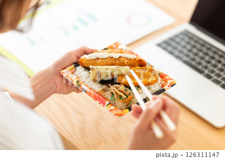会社のデスクでのり弁当を食べるミドル女性 会社のデスクでのり弁当を食べるミドル女性 126311147