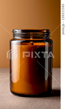 A brown glass jar with a candle inside of it 126311585