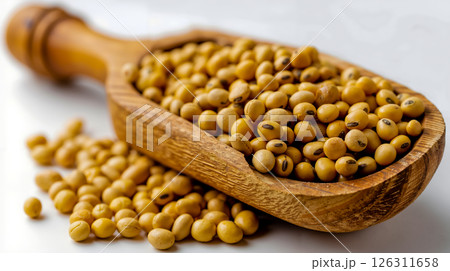 A wooden spoon filled with soy beans on a white surface 126311658