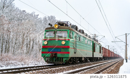 Freight train hauled by an old soviet electric locomotive in winter in Chernihiv Oblast of Ukraine 126311875