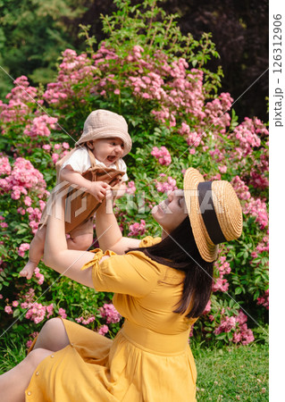 Joyful Mother and Baby in Blooming Garden 126312906