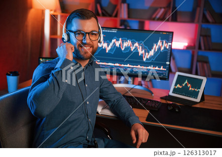 Stock trader is working by pc indoors. Conception of exchange and money Stock trader is working by pc indoors. Conception of exchange and money 126313017