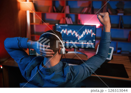 View from behind. Stock trader is working by pc indoors. Conception of exchange and money View from behind. Stock trader is working by pc indoors. Conception of exchange and money 126313044