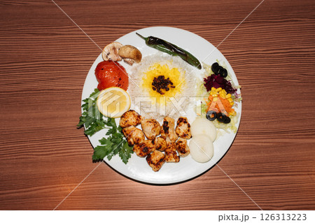 Turkish kebab plate with rice and chicken and vegetables Turkish kebab plate with rice and chicken and vegetables 126313223