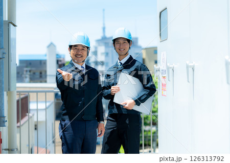 現場で打ち合わせする作業服のビジネスマン 現場で打ち合わせする作業服のビジネスマン 126313792