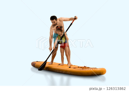 Father helps daughter learn paddling technique on sup board, exploring and learning against light studio background. Composite image. 126313862