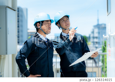現場で打ち合わせする作業服のビジネスマン 現場で打ち合わせする作業服のビジネスマン 126314015