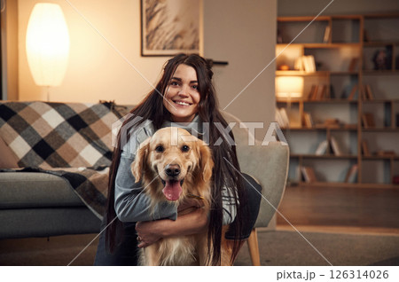 Portrait of woman that is with golden retriever dog at home 126314026