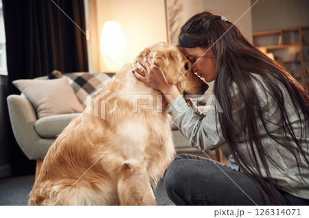 Close up view, portrait. Woman is with golden retriever dog at home Close up view, portrait. Woman is with golden retriever dog at home 126314071