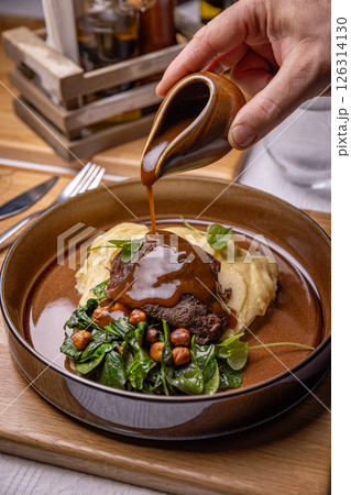 Restaurant chef pouring gravy sauce on a plate Restaurant chef pouring gravy sauce on a plate 126314130