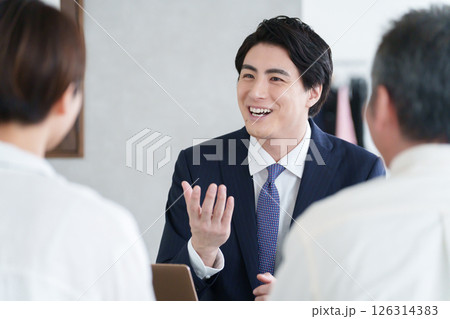 打ち合わせする営業マンと親子の客 126314383