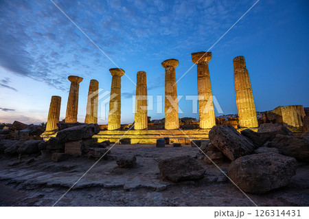 Illuminated temple of heracles standing in the valley of the temples archaeological park at dusk, agrigento, sicily, italy 126314431