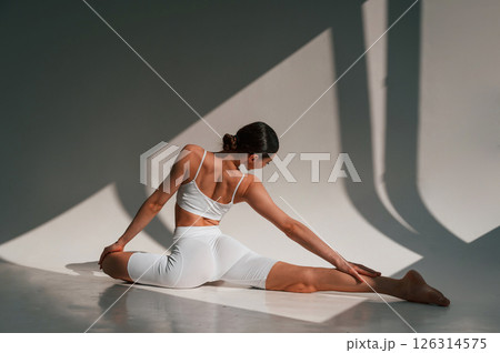 Young caucasian woman with slim body shape is indoors in the studio. Fitness exercises 126314575