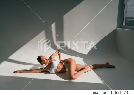 Woman with slim body shape is indoors in the studio. Model is posing 126314740