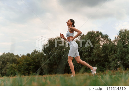 Running, everyday sport routine. Young caucasian woman with slim body shape is in the fitness clothes outdoors 126314810
