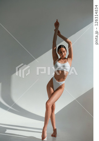 Tall figure. Young caucasian woman with slim body shape is indoors in the studio 126314834