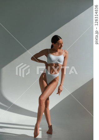 Tall figure. Young caucasian woman with slim body shape is indoors in the studio Tall figure. Young caucasian woman with slim body shape is indoors in the studio 126314836