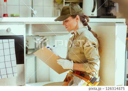 Plumber Checking Under Sink 126314875