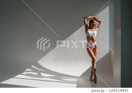 In underwear. Young caucasian woman with slim body shape is indoors in the studio In underwear. Young caucasian woman with slim body shape is indoors in the studio 126314941