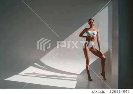 In underwear. Young caucasian woman with slim body shape is indoors in the studio 126314943