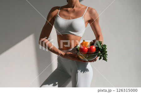 Conception of healthy eating. With fruits. Young caucasian woman with slim body shape is indoors in the studio 126315000