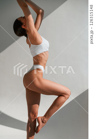 Model is posing. Young caucasian woman with slim body shape is indoors in the studio 126315148