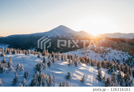 Background with amazing sunset. Winter aerial landscape of majestic Carpathian mountains Background with amazing sunset. Winter aerial landscape of majestic Carpathian mountains 126316161