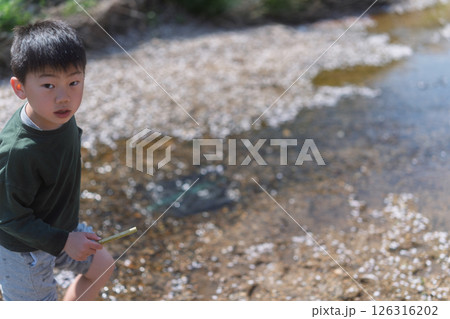 春の日差しの中川遊びをしている少年 春の日差しの中川遊びをしている少年 126316202