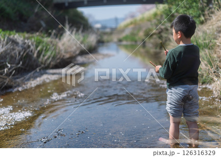春の日差しの中川遊びをしている少年 春の日差しの中川遊びをしている少年 126316329