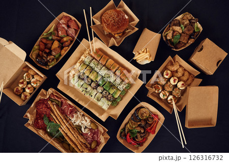 Top view of table with food on it. Meat, vegetables, sushi, French fries, burger, mushrooms Top view of table with food on it. Meat, vegetables, sushi, French fries, burger, mushrooms 126316732