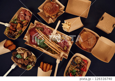 Top view of table with food on it. Meat, vegetables, French fries, burger, mushrooms 126316740