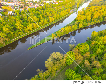 An aerial view captures the meeting of the Vltava and Labe rivers near Melnik, Czechia. Lush greenery surrounds the rivers, showcasing the beauty of this natural landscape. 126316828