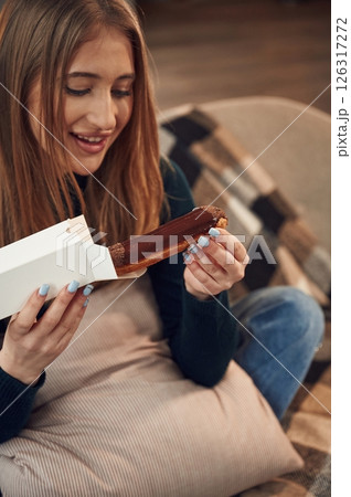 Woman is sitting and taking the sweet dessert from the paper eco box 126317272