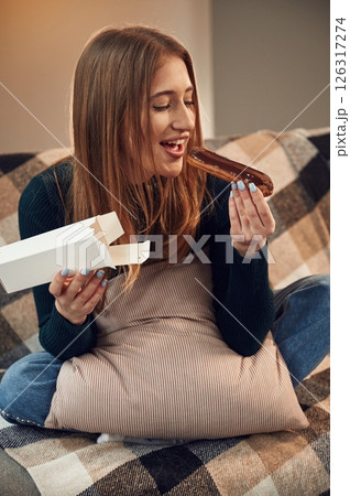 Woman is sitting and taking the sweet dessert from the paper eco box Woman is sitting and taking the sweet dessert from the paper eco box 126317274