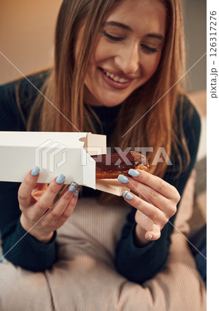 Woman is sitting and taking the sweet dessert from the paper eco box 126317276