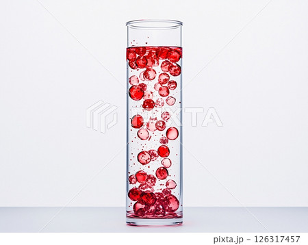 Red bubble mixture in a transparent glass tube with clear liquid and vibrant colorful interactions 126317457