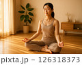 朝日の差し込む部屋で瞑想する女性 126318373