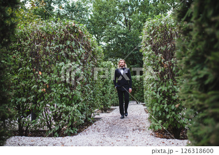 Portrait of handsome young bridegroom with elegant stylish haircut on the territory of country hotel 126318600