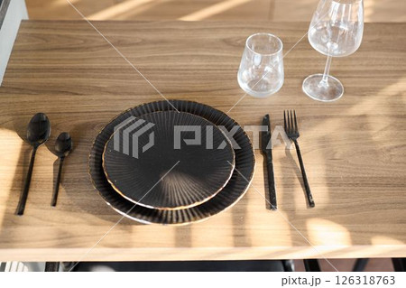 An Elegant Dining Setup Featuring Stylish Black Plates Along With Sophisticated Glassware An Elegant Dining Setup Featuring Stylish Black Plates Along With Sophisticated Glassware 126318763