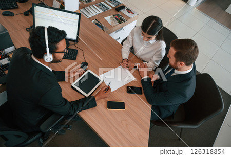 Two men and woman are sitting in the office and working 126318854