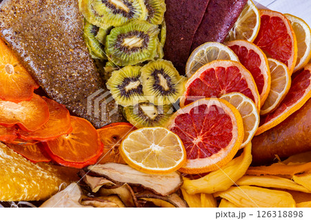 Close up of assorted dried fruits including kiwi citrus and pear creating a colorful organic arrangement Close up of assorted dried fruits including kiwi citrus and pear creating a colorful organic arrangement 126318898