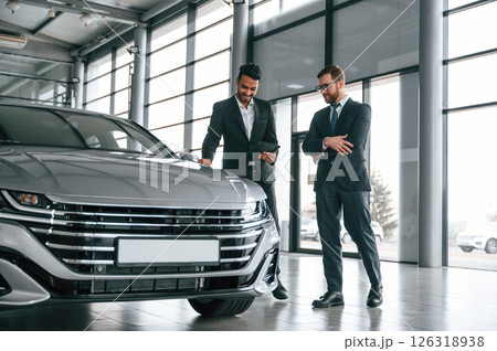 Talking about automobile. Man is consulting the customer in the car showroom 126318938