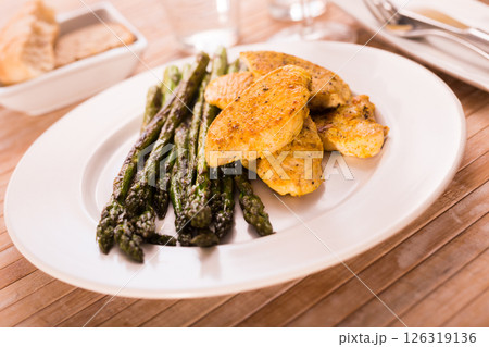 Cooked dish. Chicken nuggets with green asparagus on plate Cooked dish. Chicken nuggets with green asparagus on plate 126319136