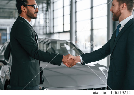 Two businessmen are working together in the car showroom Two businessmen are working together in the car showroom 126319210